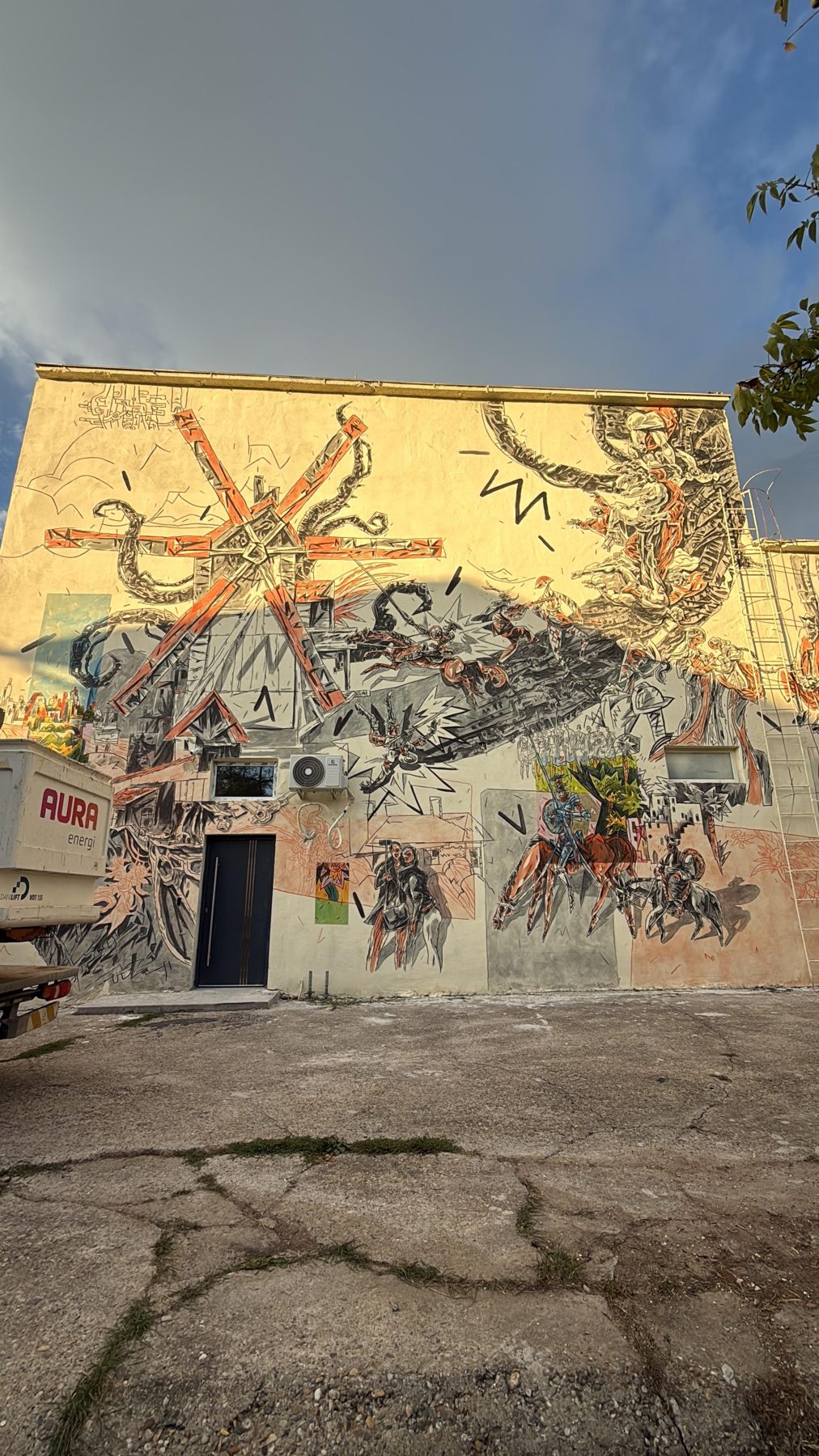 Detaliu din pictura murală de pe Moara Artiștilor: personaje și o roată de moară pictate pe perete